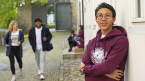 Prospective student leaning against a wall