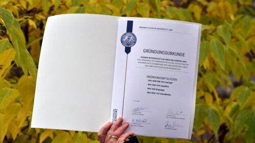Gründungsurkunde des Verbundes WKJ, im Hintergrund gelblich grünes Laub