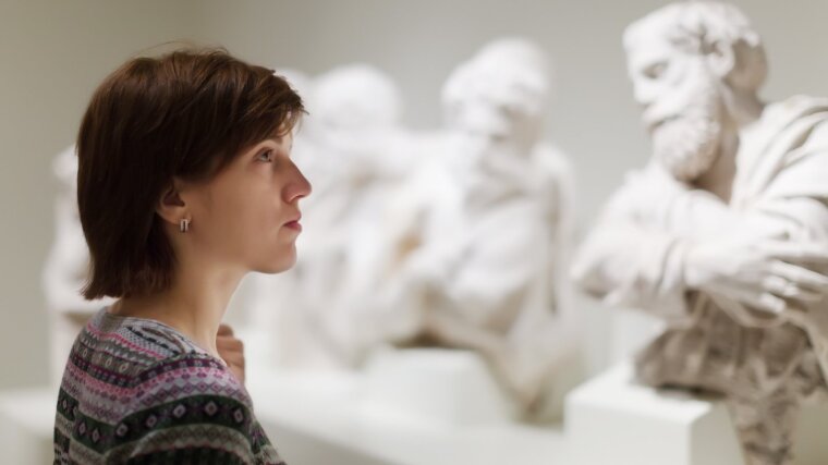 Student looks at sculptures