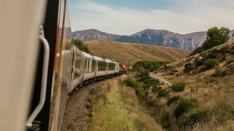 Train driving in curve, mountains in background