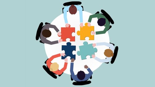 Students at a table with puzzle pieces