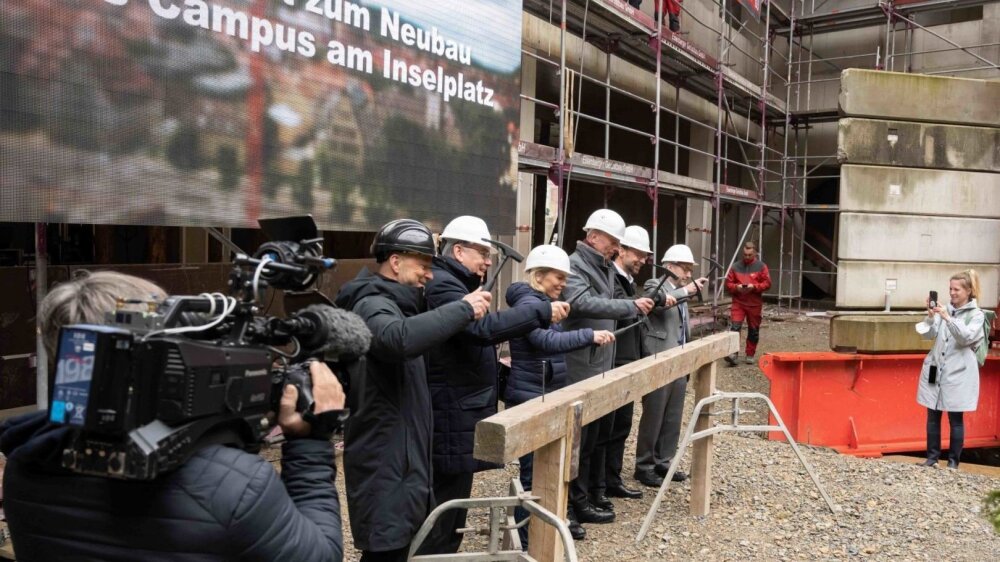 placeholder image — Representatives of the press and other media covering the topping-out ceremony for the new Inseplatz Campus.