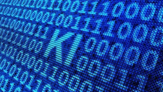 Die Buchstaben K und I (für Künstliche Intelligenz) werden zwischen Reihen von Nullen und Einsen dargestellt.
