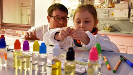 Ein Kind stellt während der Langen Nacht der Wissenschaften Parfum her