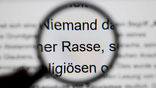 Lupe vergrößert Textstelle aus dem Grundgesetz