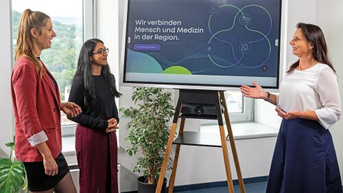 An einem Screen-Board im Jentower besprechen sich drei Frauen zur ganzheitlichen Gesundheitsversorgung im ländlichen Raum.