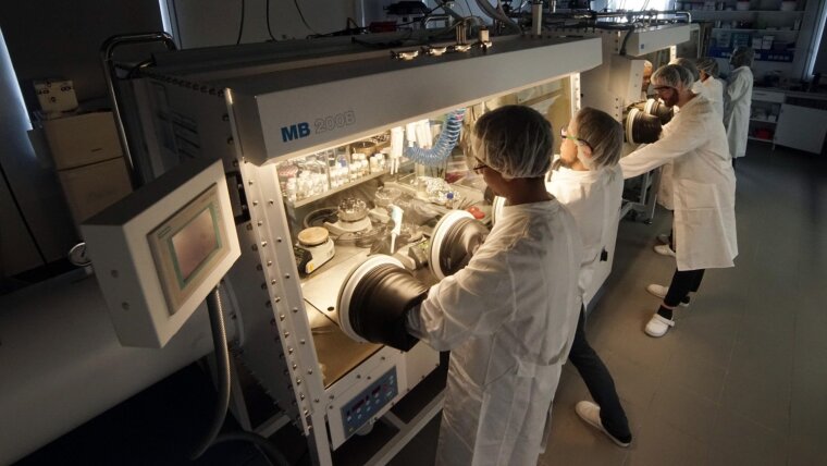 Studierende und Lehrende in einem Labor für organische Solarzellen, Batterien und Solarbatterien.