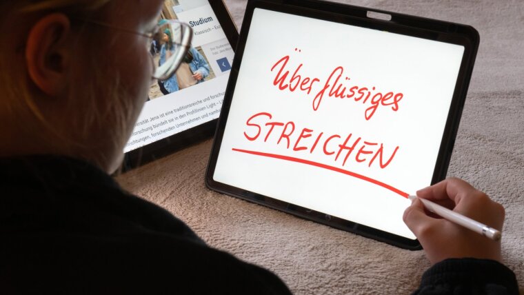 Eine Studentin gibt einen Schreibtipp am Tablet wider.