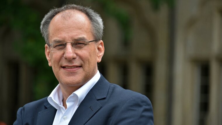 Prof. Dr. Uwe Cantner vor dem Hauptgebäude der Universität Jena.
