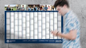 Junger Mann geht am Wandkalender 2025 der Universität vorbei.