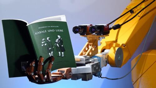 Ein Roboter h&auml;lt ein Buch in der k&uuml;nstlichen Hand.