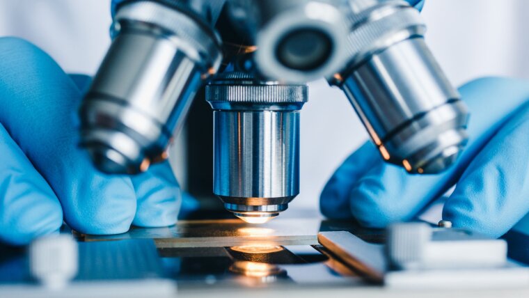 Close-up shot of microscope with metal lens at laboratory.