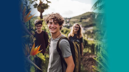 Junge steht in der Natur und lächelt in die Kamera