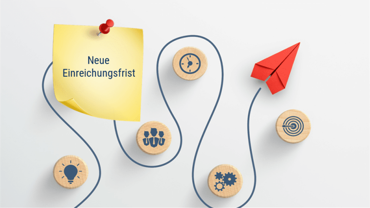 Roter Papierflieger und Holzklötzer mit Icons auf weißem Hintergrund, mit dem Post it darauf neue Einreichungsfrist