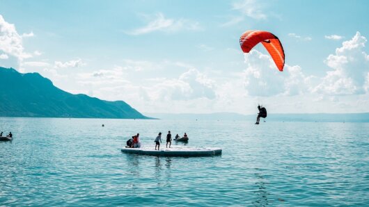 Gleitschirmflieger landet auf einem See