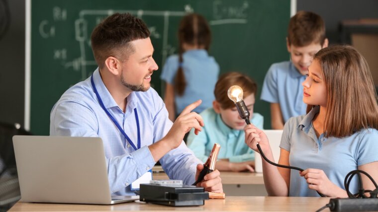 Ein Lehrer erklärt einer Schülerin ein physikalisches Phänomen.