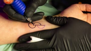 Ein Arm wird mit dem Symbol für Organspende tätowiert.
