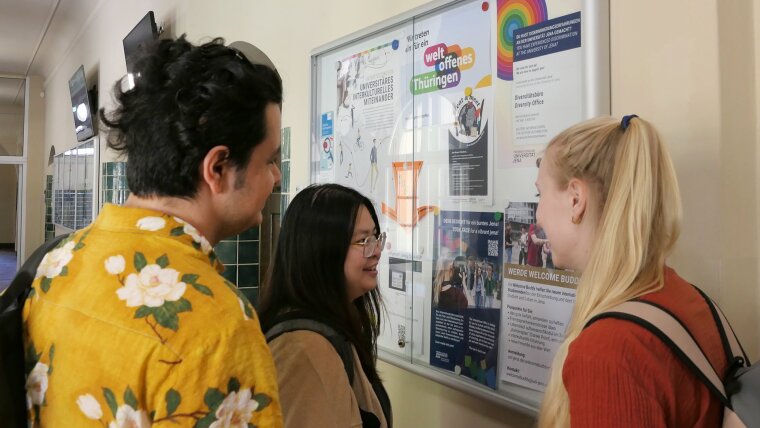 Students read the NEWS in the showcase of the International Office