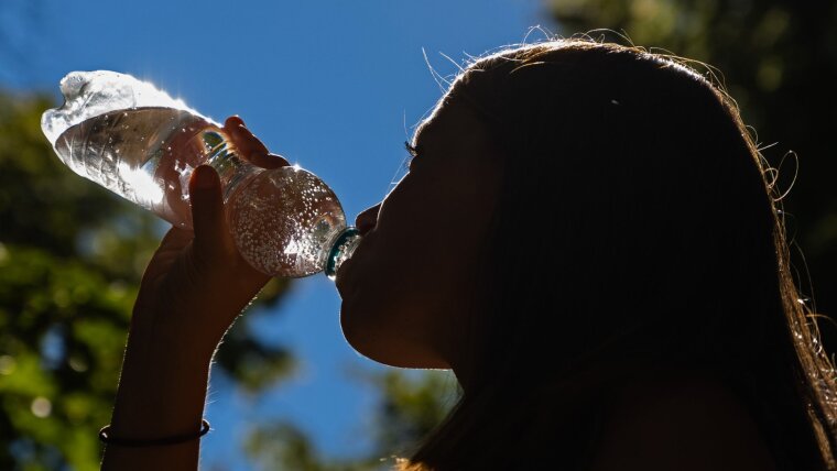 Eine Frau trinkt sprudelndes Wasser aus einer PET-Flasche am 03.08.2022 an der Friedrich-Schiller-Universität Jena in Jena.