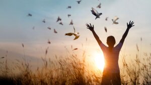 Woman at sunset with pigeons