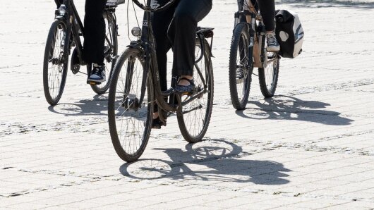 Studierende fahren mit dem Fahrrad auf dem Campus am Ernst-Abbe-Platz