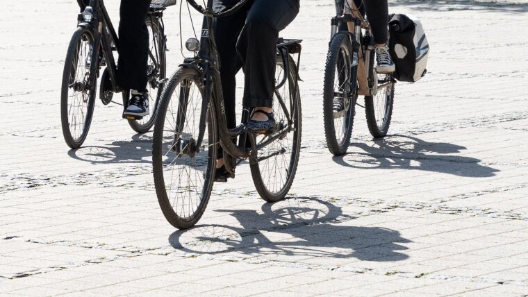 Studierende fahren mit dem Fahrrad auf dem Campus am Ernst-Abbe-Platz