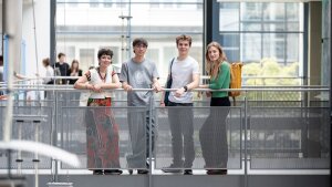 Vier junge Menschen stehen im Foyergebäude am Campus Ernst-Abbe-Platz Jena
