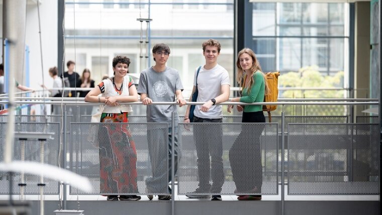 Vier junge Menschen stehen im Foyergebäude am Campus Ernst-Abbe-Platz Jena