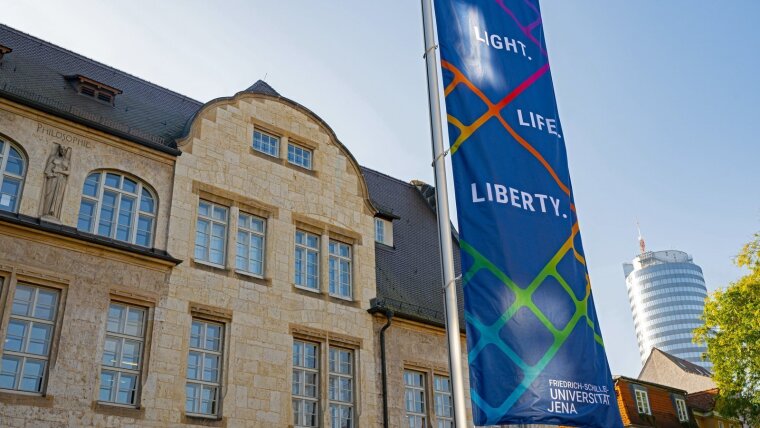 Eine Fahne mit dem Slogan "Light, Life, Liberty" weht am Universitätshauptgebäude