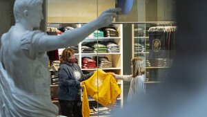 Zwei Frauen stehen im Unishop. Eine berät die andere. Sie halten beide einen Pulli in der Hand.