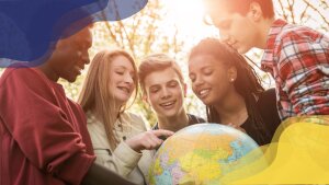 Five young people looking at a globe