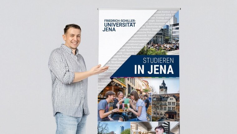 *nicht alle Größen auf Lager, aber jederzeit bestellbar Ein junger Mann vor dem Roll-up der Universität Jena – Studieren in jena