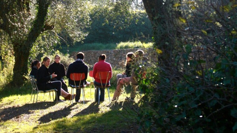 Personen im Stuhlkreis auf Wiese