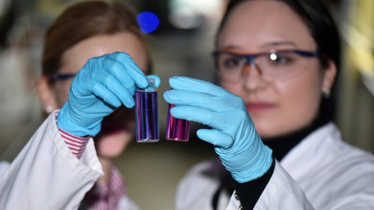 Researchers investigate functionalised polymer nanoparticles in a test tube in a JCSM laboratory.