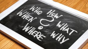 Eine Täfelchen, auf welchen um ein "?" in der Mitte herum "Who,How, What, Why, Where, When" steht