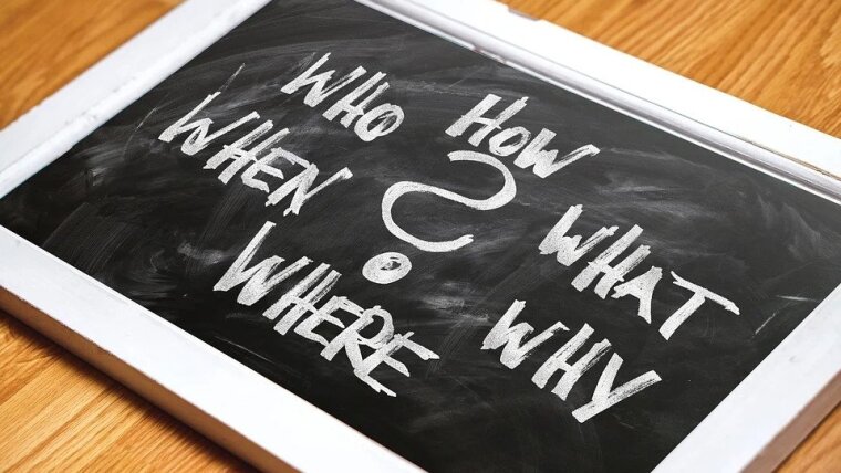 Eine Täfelchen, auf welchen um ein "?" in der Mitte herum "Who,How, What, Why, Where, When" steht