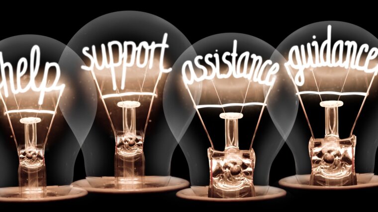 Auf schwarzem Grund leuchten vier Glühbirnen, deren Drähte jeweils eines der Worte "help, support, assistance, guidance" formen