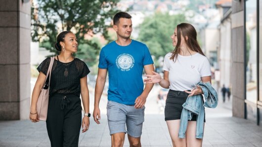 Drei Studierende unterhalten sich auf dem Weg zum Campus Ernst-Abbe-Platz.