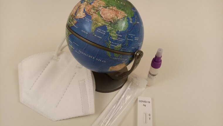 Globe with an FFP2 mask and Covid19 test kit