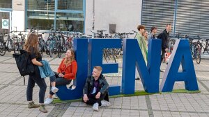 Studierende und JENA_Buchstaben auf dem Campus