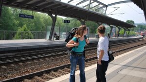 Zwei junge Menschen mit Gepäck am Paradiesbahnhof