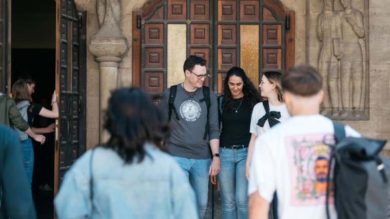 Studierende am Eingang vom Unihauptgebäude