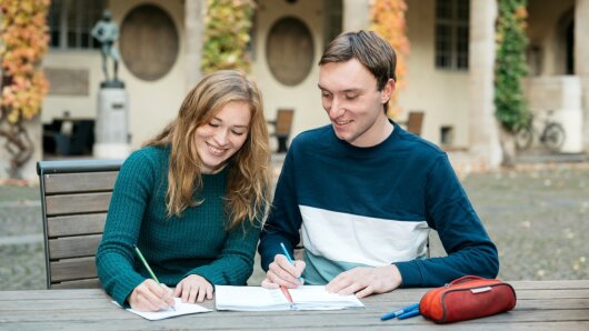 Studierende im Innenhof des Universitätshauptgebäudes