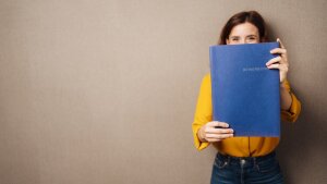 Student holds application folder in her hands