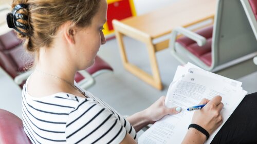 Studentin füllt ein Formular aus