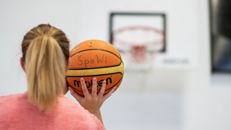 Female student throwing a basketball