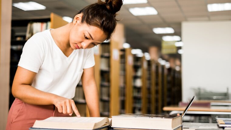 Studentin liest in der Bibliothek