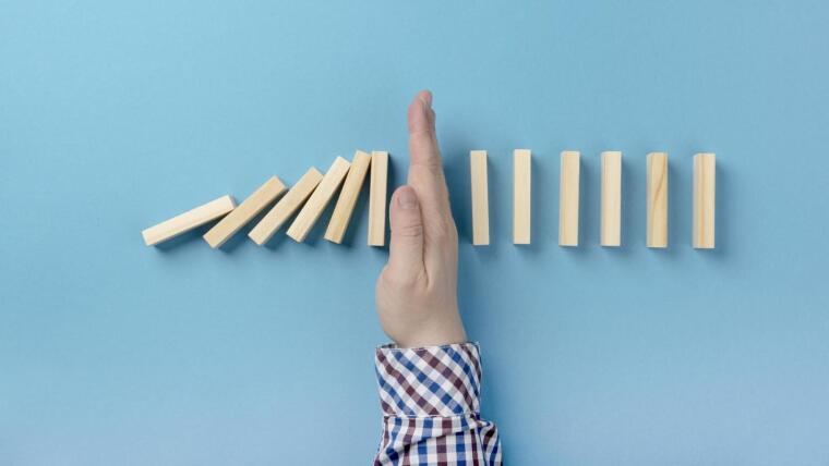 Hand between wooden dominoes