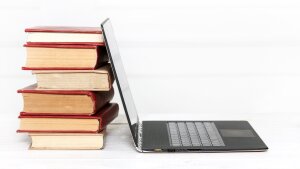 Laptop und ein Bücherstapel