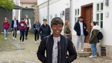 Several students in front of the buildings of the Frommann estate in Jena